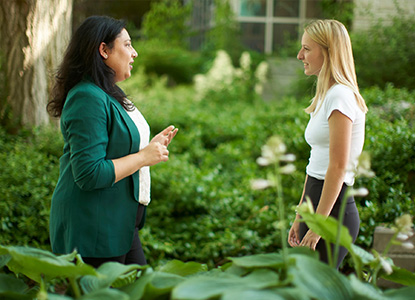 Two people talking face to face in garden